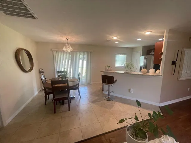 a living room with furniture a dining table and kitchen view