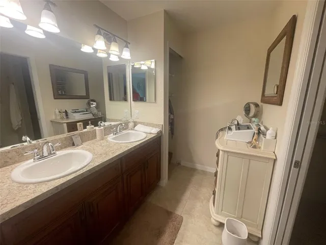 a en suite bathroom with a double vanity sink and a mirror