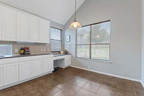 a kitchen with granite countertop white cabinets and white appliances