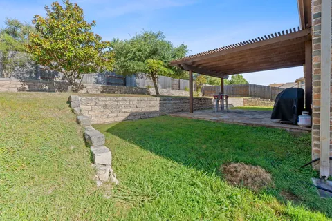 a view of a backyard with table and chairs under an umbrella