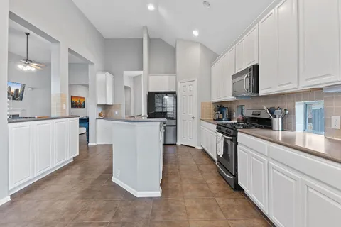 a large kitchen with cabinets and stainless steel appliances