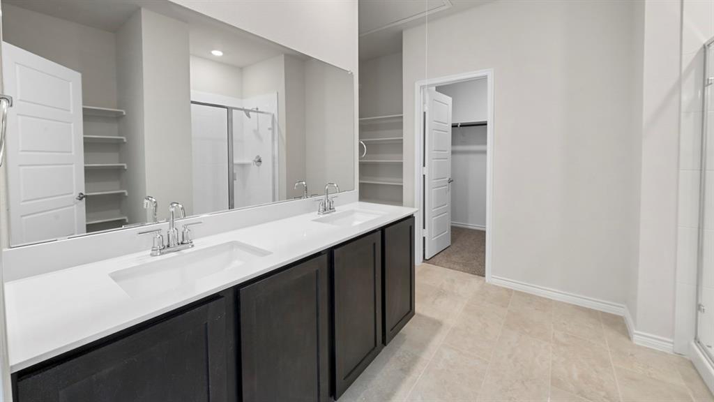 412 Carthage Street Caddo Mills, TX 75135 - Photo 2 of 32 Double vanity with integrated sinks, dark wood-finish cabinetry, and a full-width mirror