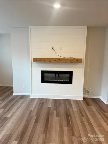 a view of a room with wooden floor and a fireplace