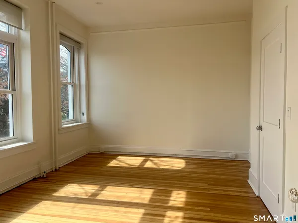 a view of a room with wooden floor and a window