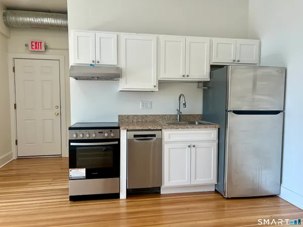a kitchen with a refrigerator sink and cabinets