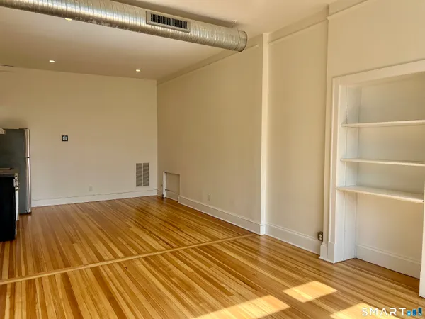 a view of a room with wooden floor and a ceiling fan