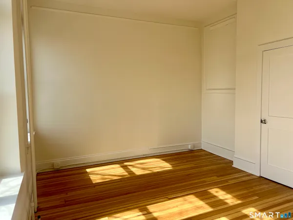 a view of empty room with wooden floor