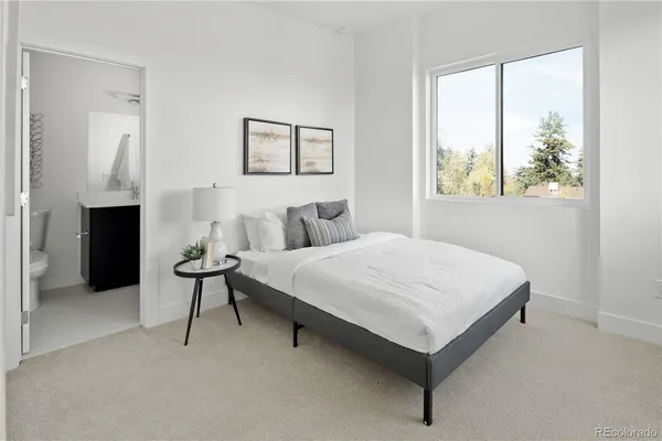 a bedroom with a bed and a painting on the wall