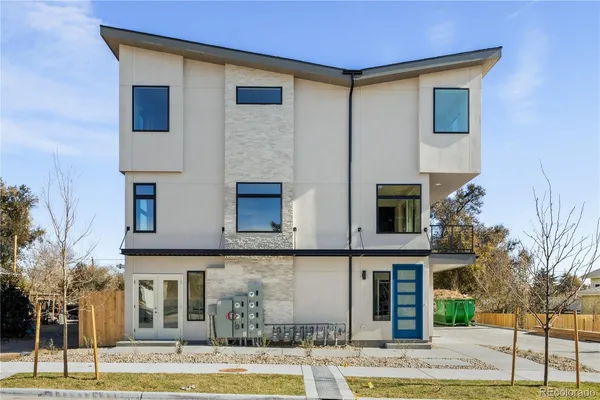 a front view of a house with garage and plants