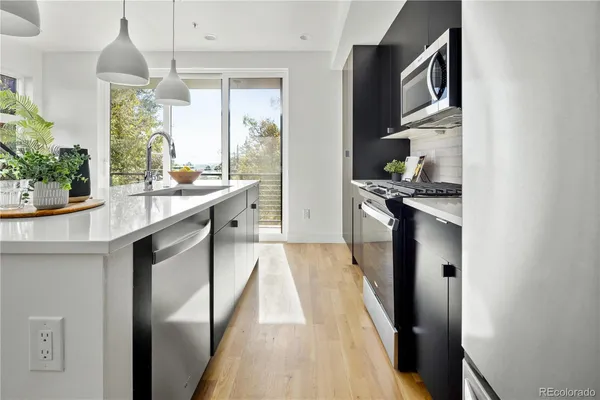 a kitchen with stainless steel appliances granite countertop a sink and wooden cabinets