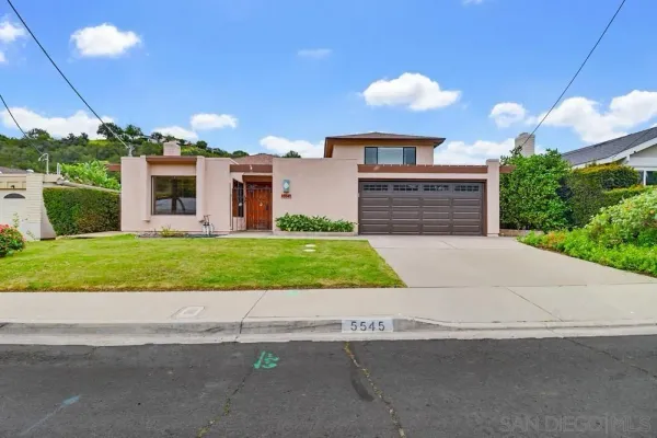 a front view of a house with a garden and yard