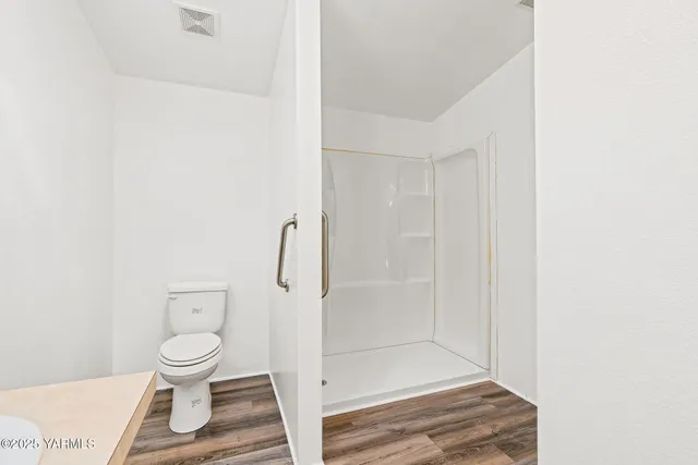 a bathroom with a toilet and a shower