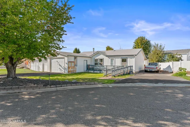 a view of a house with a big yard and potted plants