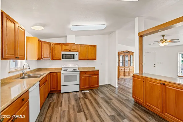 a kitchen with a sink wooden floor and stainless steel appliances