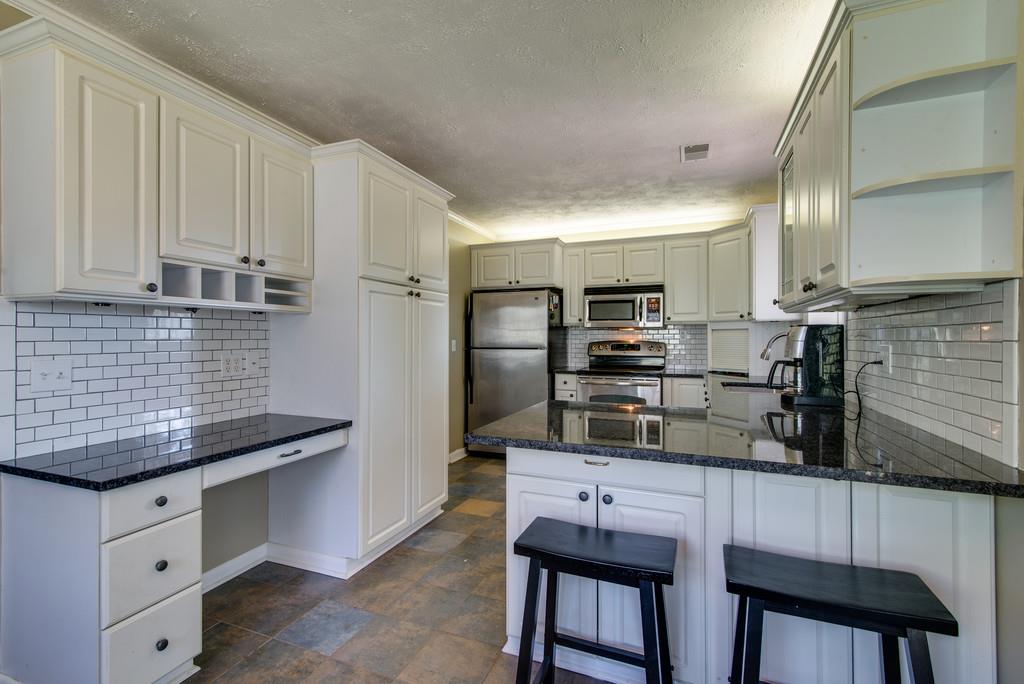 5019 Chaffin Drive Nashville, TN 37221 - Photo 8 of 30 a kitchen with stainless steel appliances granite countertop a sink and refrigerator