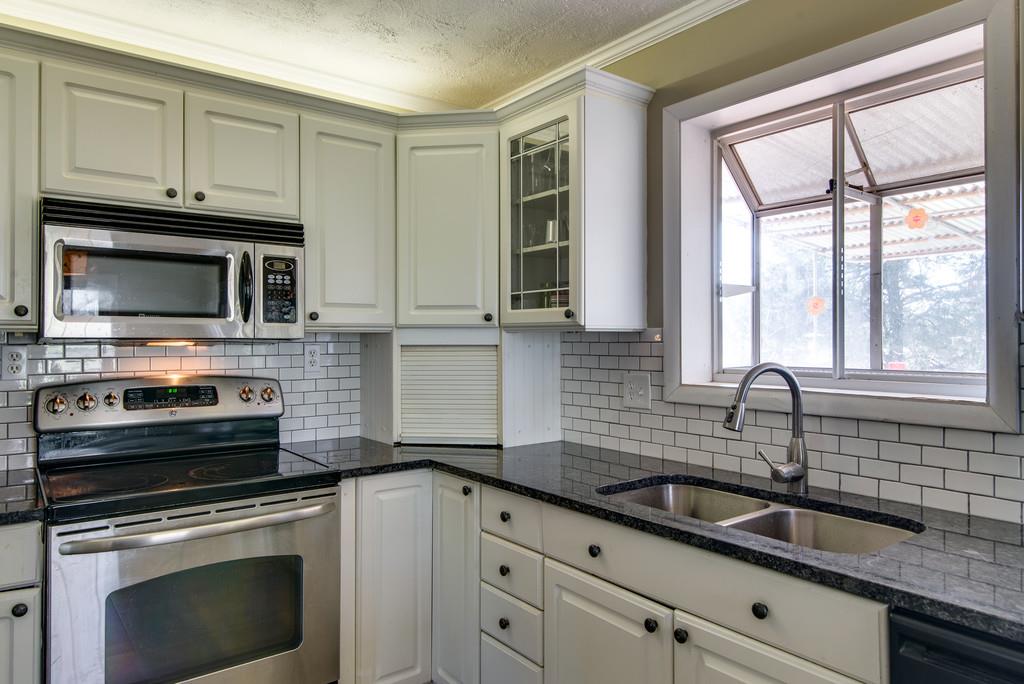 5019 Chaffin Drive Nashville, TN 37221 - Photo 10 of 30 a kitchen with granite countertop a sink stainless steel appliances a window and cabinets