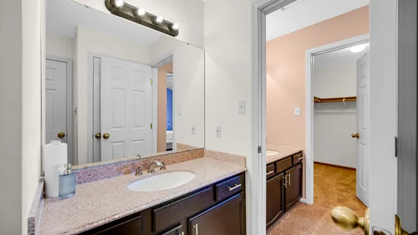 a bathroom with a granite countertop sink and a mirror