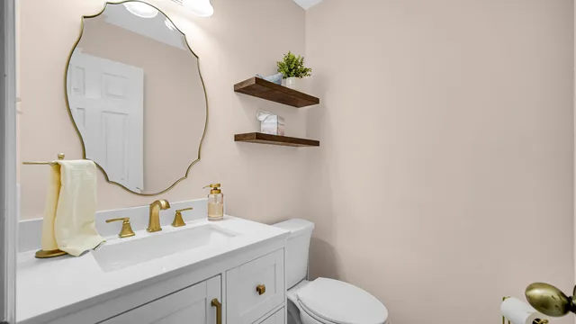a bathroom with a sink mirror and toilet