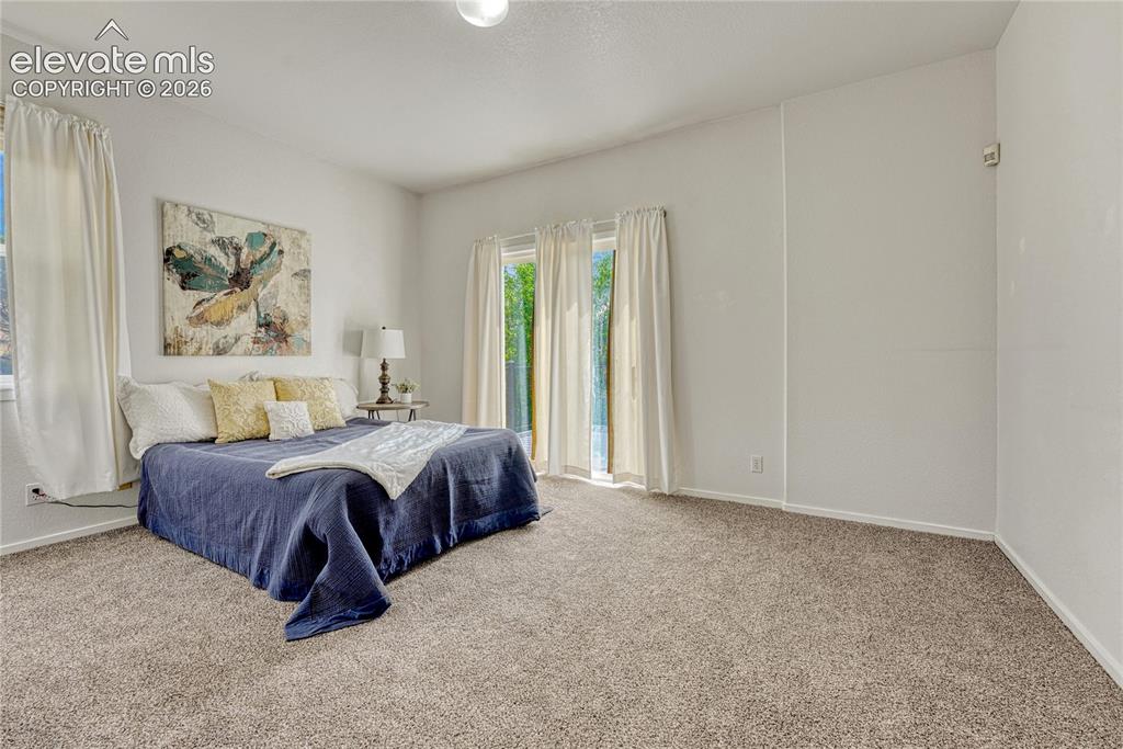7285 Julynn Road Colorado Springs, CO 80919 - Photo 20 of 45 a spacious bedroom with a bed and a window