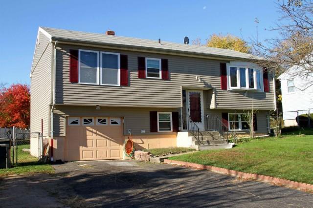 58 Meadow Lark Road Naugatuck, CT 06770 - Photo 1 of 1 a front view of a house with garden and trees
