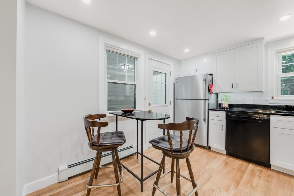 21 Cutler Drive Ashland, MA 01721 - Photo 3 of 28 a kitchen with stainless steel appliances granite countertop a stove a refrigerator a dining table and chairs with wooden floor