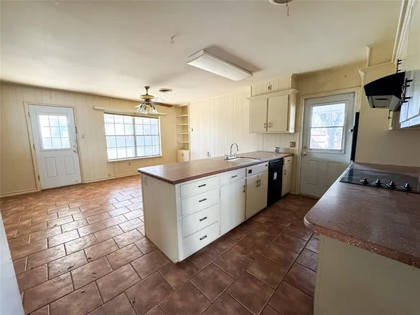 a kitchen with a stove sink and cabinets