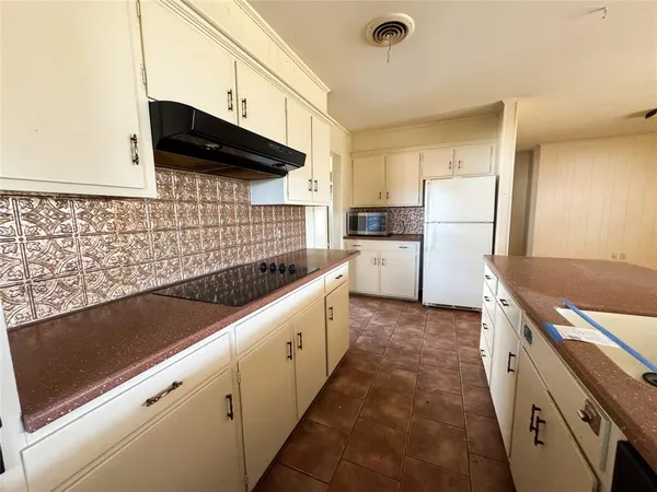 a kitchen with refrigerator and stove