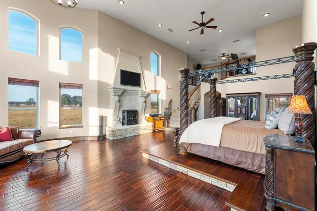 a spacious bedroom with bed and wooden floor