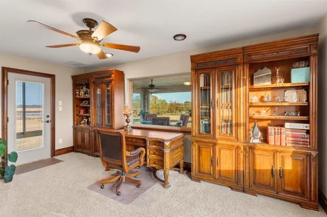 a view of a workspace with furniture and a window