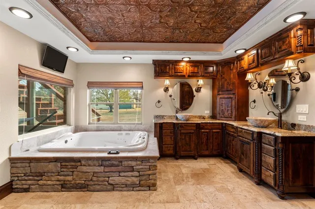 a spacious bathroom with a tub sink and mirror