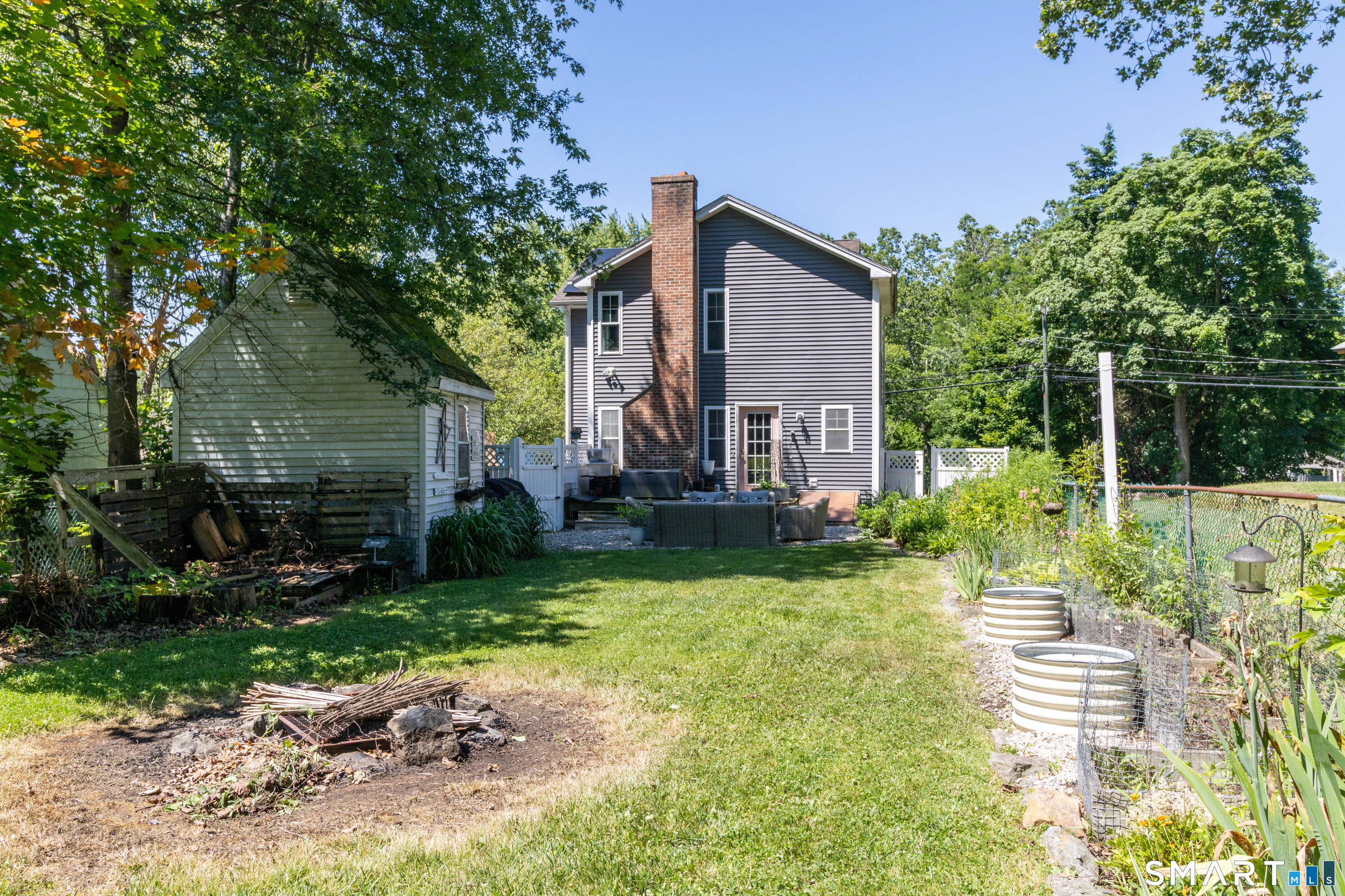 18 Hicksville Road Cromwell, CT 06416 - Photo 33 of 34 Fenced in Bay Yard with shed, stone patio, deck off of house, fire pit and mature garden beds.