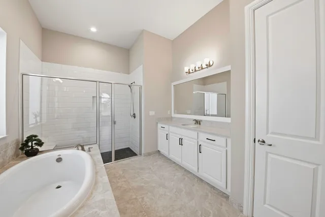 a bathroom with a tub a sink and mirror