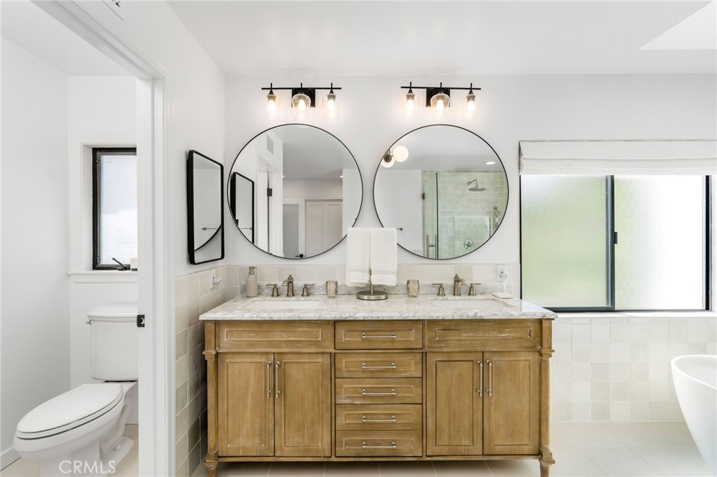 24743 Vantage Point Terrace Malibu, CA 90265 - Photo 38 of 64 a bathroom with a granite countertop toilet a sink and a mirror