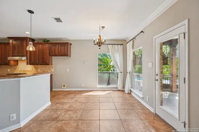 a view of a livingroom with a ceiling fan & windows