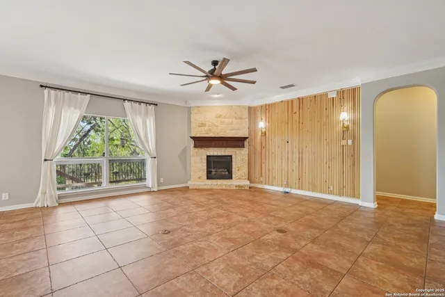 a view of an empty room with a fireplace and a window