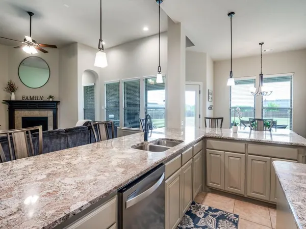 a large kitchen with granite countertop a stove a sink a window and a fireplace