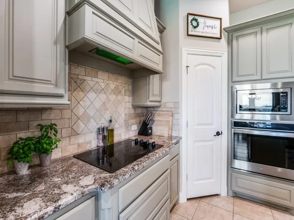 a kitchen with granite countertop a stove a sink and a microwave