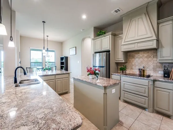 a kitchen with kitchen island granite countertop a sink stainless steel appliances and cabinets