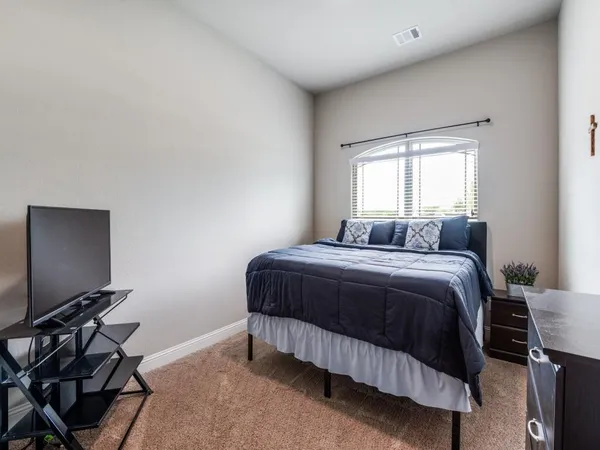 a bedroom with a bed and a flat screen tv