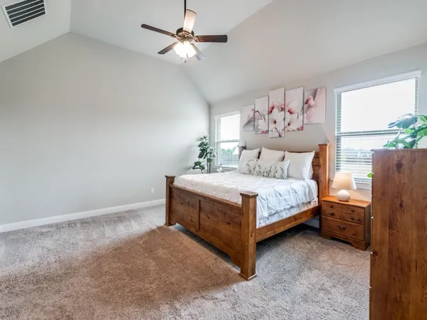 a bedroom with a bed chandelier and a window