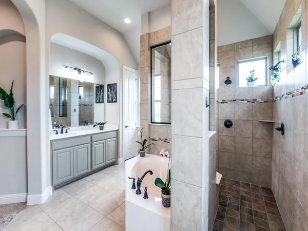 a bathroom with a double vanity sink mirror and shower
