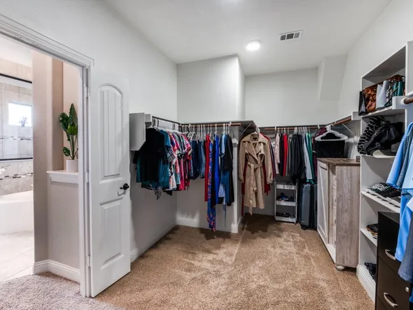 a view of walk in closet with clothes