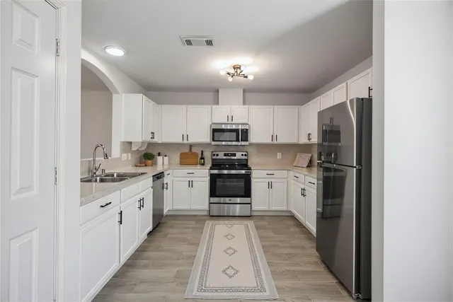 a kitchen with granite countertop a refrigerator oven a sink and dishwasher