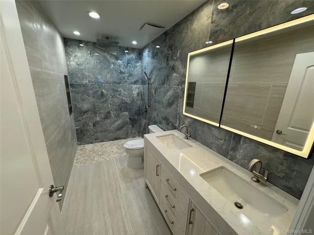 a bathroom with a double vanity sink mirror double and shower