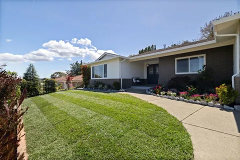 a view of a house with a backyard and a garden