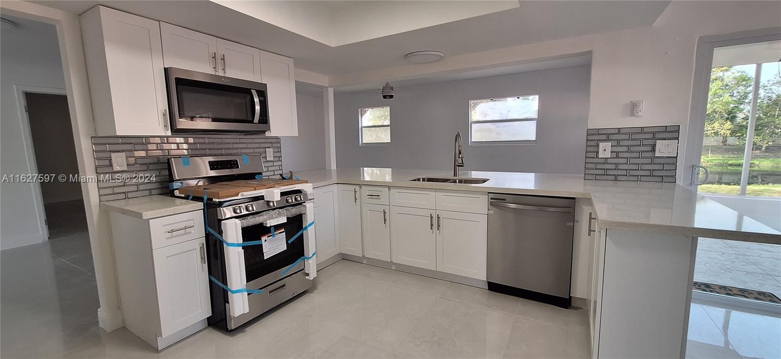 8620 Windsor Drive Miramar, FL 33025 - Photo 4 of 31 a kitchen with white cabinets and appliances