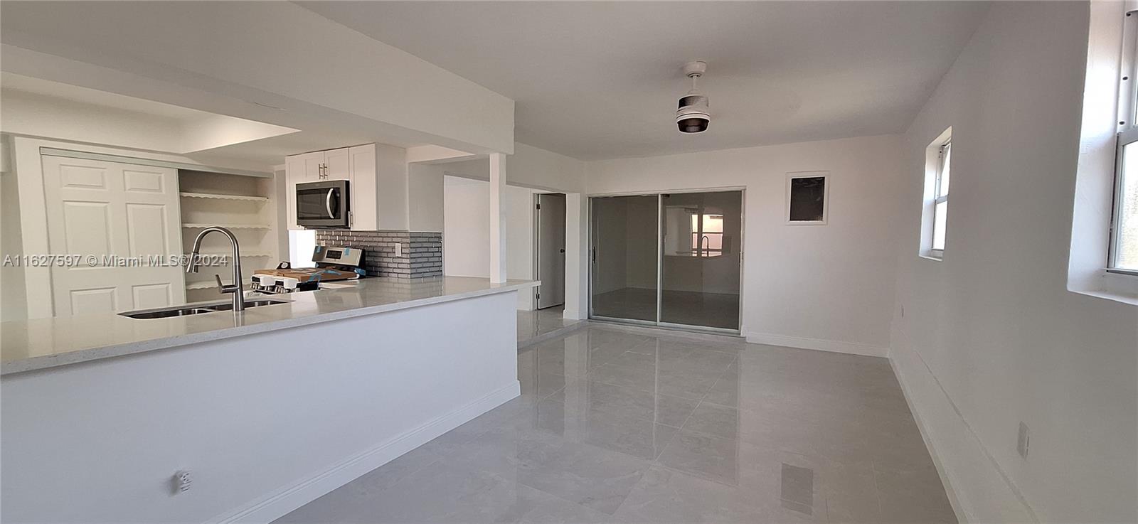 8620 Windsor Drive Miramar, FL 33025 - Photo 7 of 31 a large white kitchen with granite countertop a sink and dishwasher with a large window