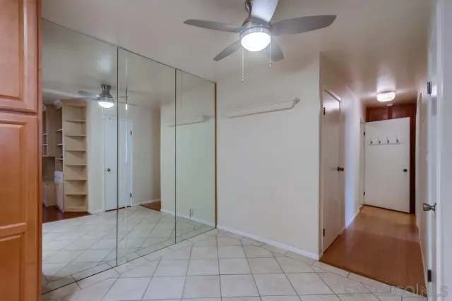 a view of a hallway with closet and a bathroom