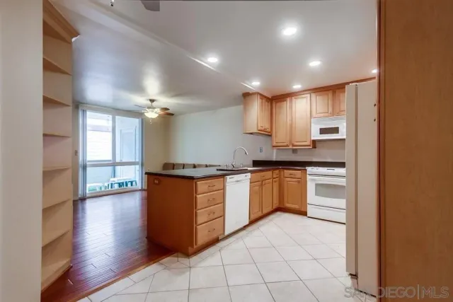 a kitchen with granite countertop a refrigerator and wooden cabinets