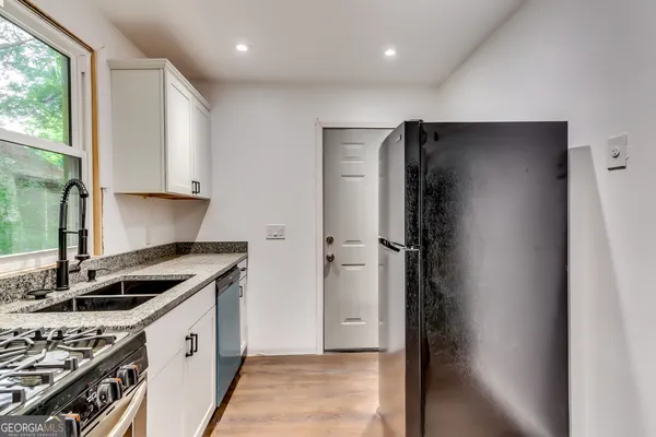a kitchen with a refrigerator and a stove top oven